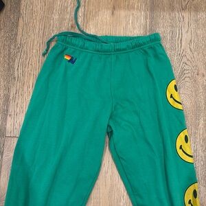 Green aviator nation, sweatpants size small with smiley faces down the leg